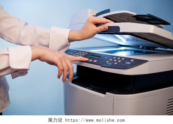 女人的手与工作复印机